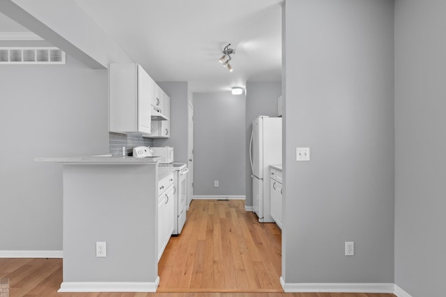 kitchen with light wood finished floors, visible vents, backsplash, white cabinetry, and white appliances