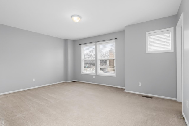 unfurnished room featuring light carpet, baseboards, and visible vents