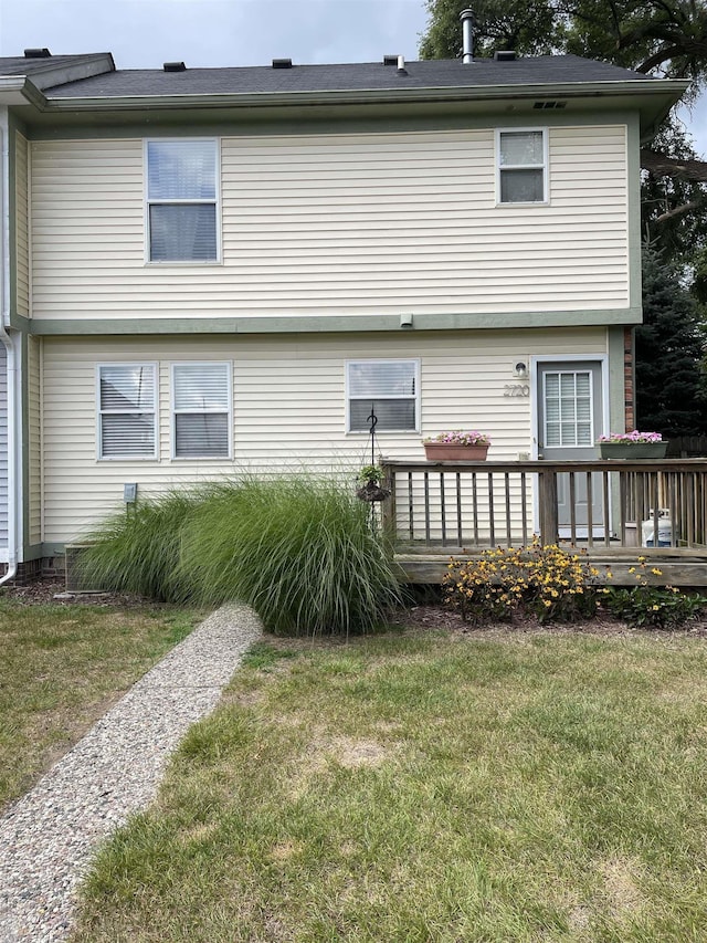 back of house with a lawn and a wooden deck