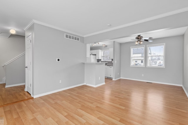 unfurnished living room with ceiling fan, visible vents, baseboards, light wood-style floors, and ornamental molding