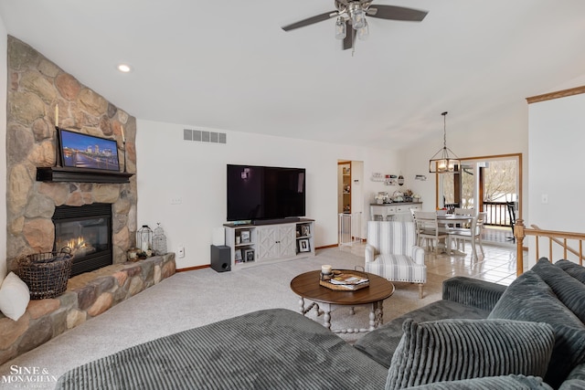 living area featuring lofted ceiling, visible vents, light carpet, a stone fireplace, and baseboards