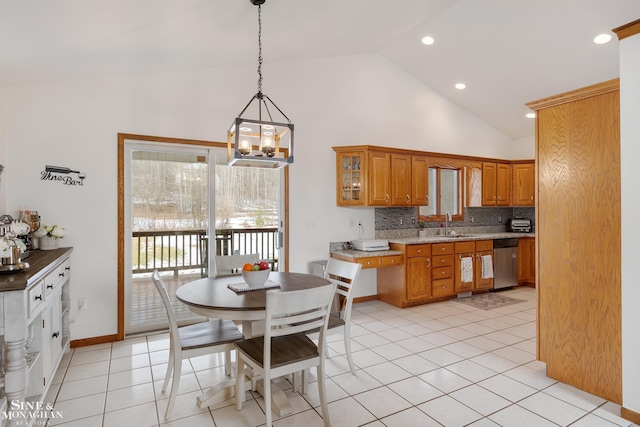 kitchen with light tile patterned floors, decorative backsplash, brown cabinets, high vaulted ceiling, and stainless steel dishwasher