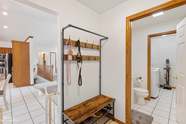 bathroom with toilet, washing machine and dryer, recessed lighting, and tile patterned floors