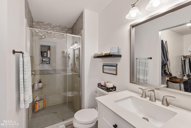 bathroom featuring a stall shower, vanity, and toilet