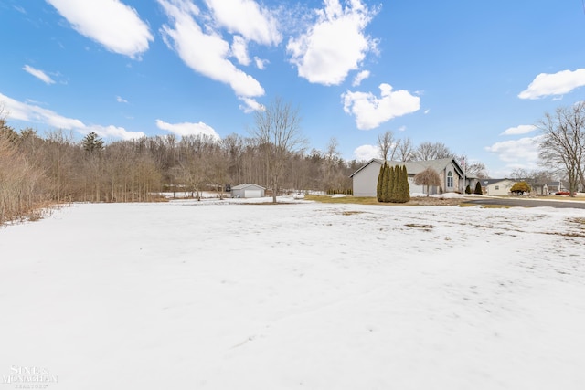 snowy yard featuring an outbuilding and a storage shed