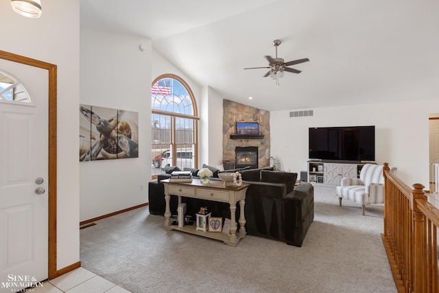 living room featuring a fireplace, light colored carpet, visible vents, high vaulted ceiling, and baseboards