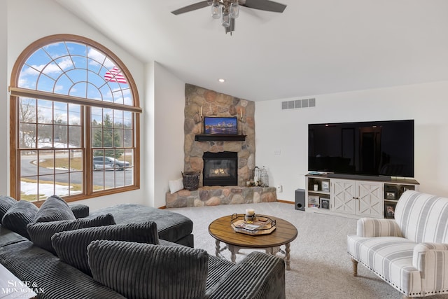 living area featuring carpet, a fireplace, visible vents, vaulted ceiling, and ceiling fan