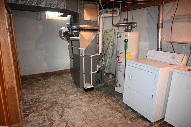 interior space featuring heating unit, water heater, and washing machine and clothes dryer