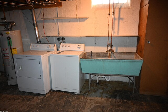 clothes washing area with laundry area, water heater, separate washer and dryer, and a sink