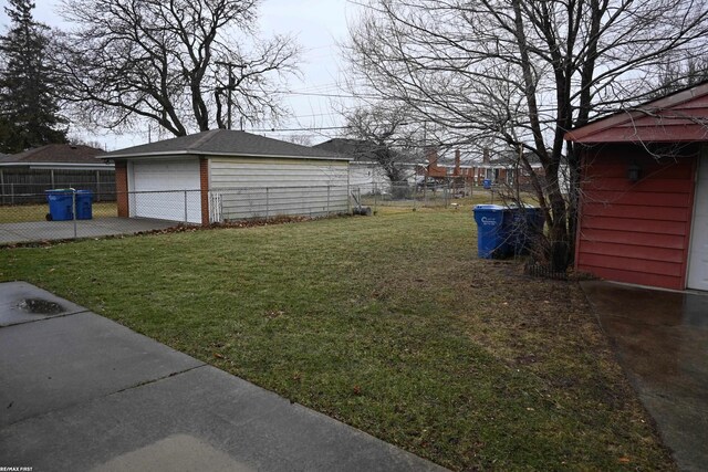 view of yard featuring an outdoor structure, fence, and a detached garage