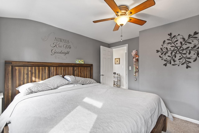 bedroom featuring carpet floors, vaulted ceiling, baseboards, and a ceiling fan