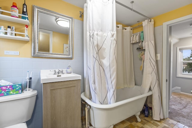 full bathroom with toilet, tile walls, and vanity