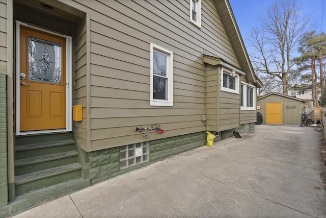 view of side of home featuring entry steps and an outbuilding