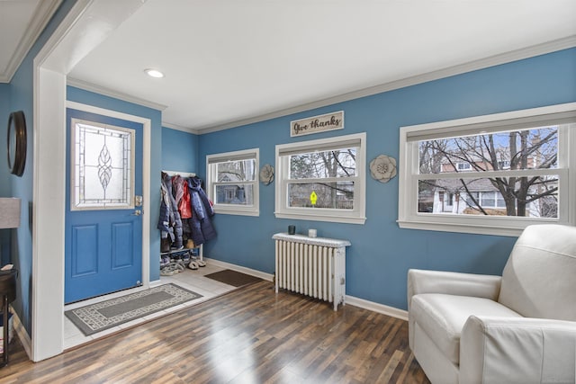 entrance foyer with baseboards, radiator heating unit, ornamental molding, and wood finished floors