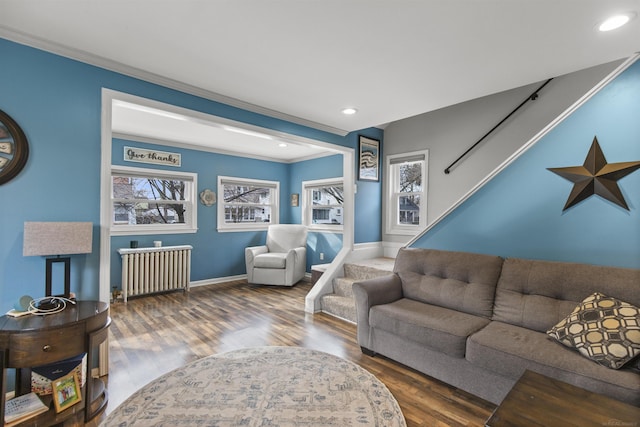 living room with recessed lighting, wood finished floors, stairs, radiator heating unit, and crown molding