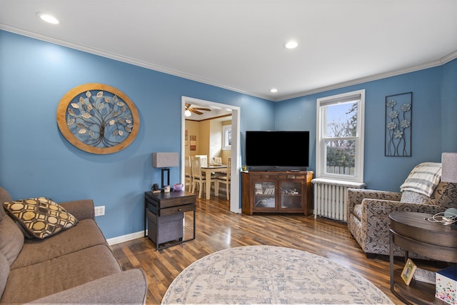 living room featuring radiator, baseboards, ornamental molding, and wood finished floors