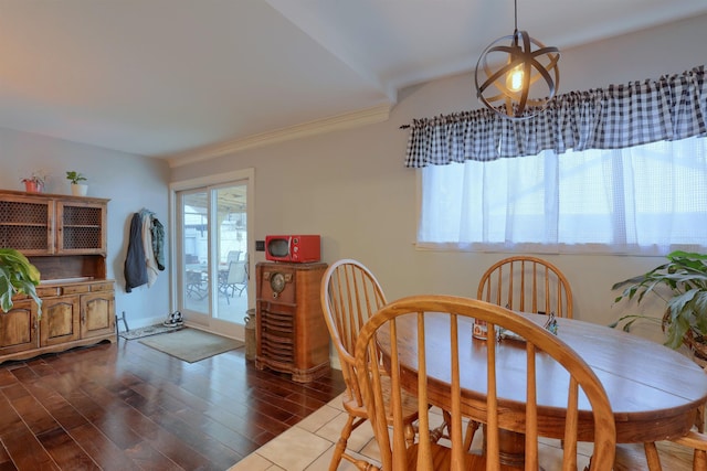 dining space featuring an inviting chandelier, baseboards, dark wood finished floors, and crown molding