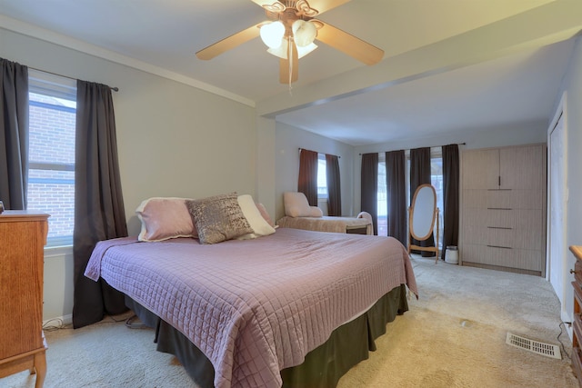 bedroom featuring light carpet, visible vents, a ceiling fan, and ornamental molding