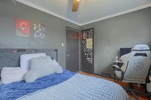 bedroom featuring ceiling fan, wood finished floors, and visible vents