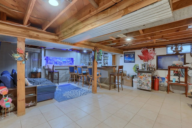 basement with tile patterned flooring and a dry bar