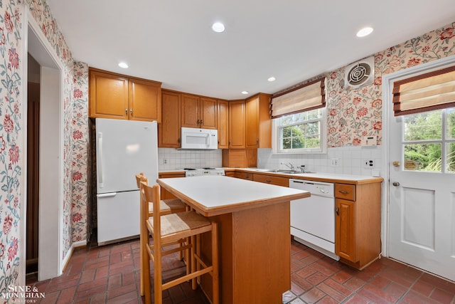 kitchen featuring brick floor, recessed lighting, white appliances, light countertops, and wallpapered walls