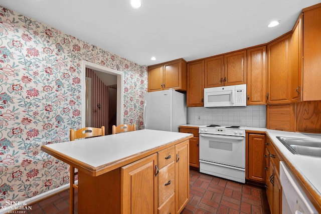 kitchen with brick floor, white appliances, light countertops, and wallpapered walls