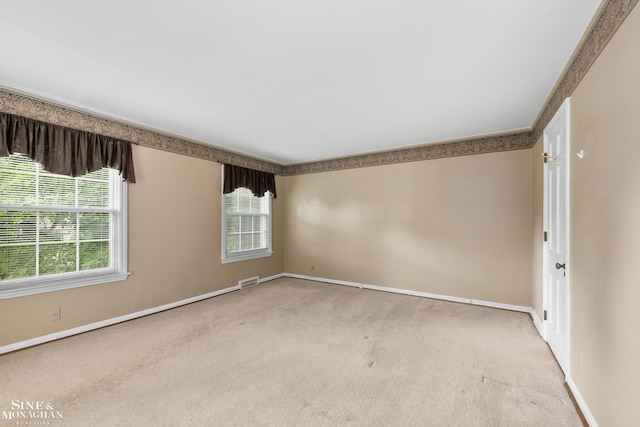 empty room with carpet flooring, visible vents, and baseboards