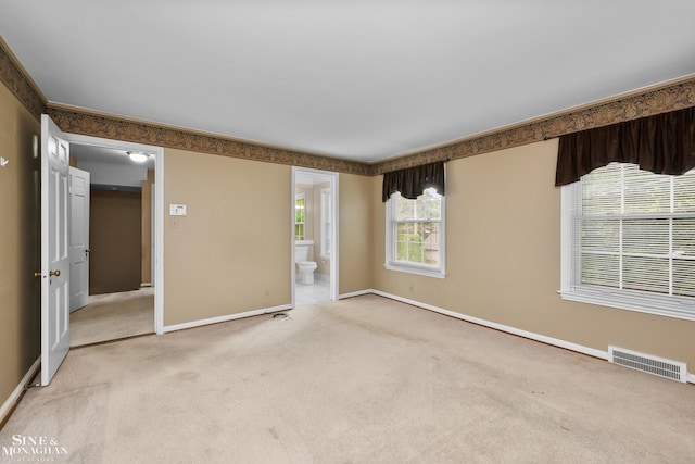 spare room with light carpet, baseboards, visible vents, and ornamental molding