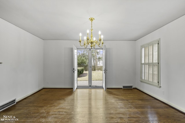 unfurnished room with a healthy amount of sunlight, visible vents, and wood finished floors