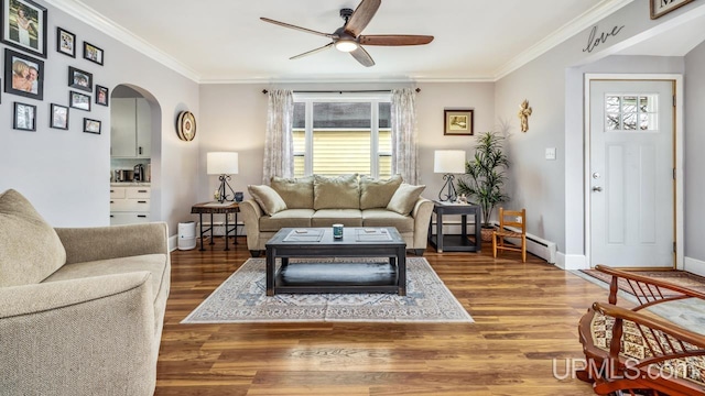 living area featuring arched walkways, crown molding, ceiling fan, wood finished floors, and baseboards