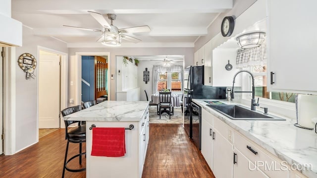 kitchen with dark wood-style flooring, white cabinets, a sink, and dishwasher