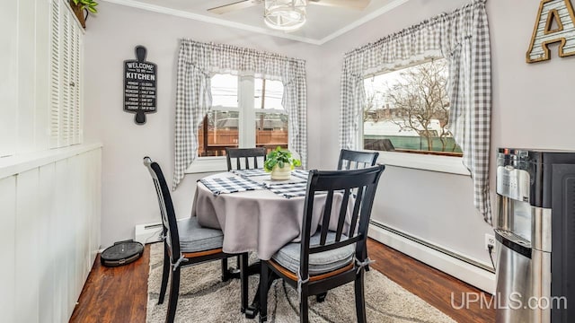 dining space featuring a ceiling fan, a baseboard radiator, wood finished floors, baseboard heating, and crown molding