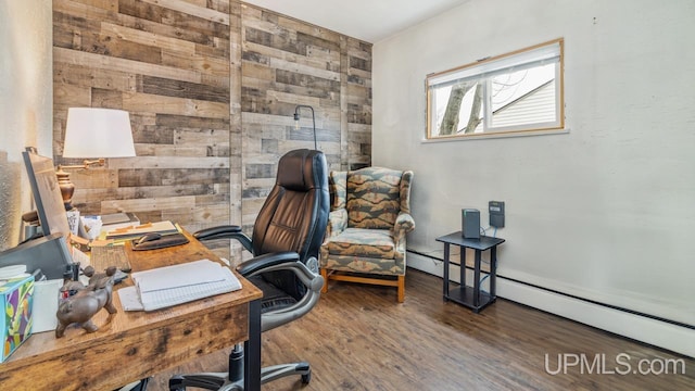 home office featuring a baseboard radiator, wooden walls, and wood finished floors