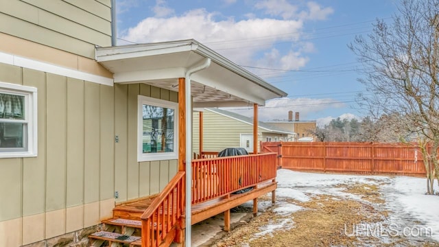 snow covered deck featuring fence