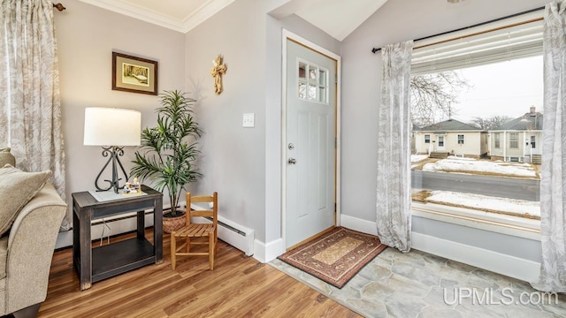 entrance foyer featuring lofted ceiling, baseboards, ornamental molding, and wood finished floors