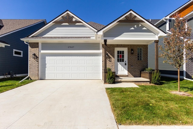 view of front of property featuring an attached garage, a front yard, concrete driveway, and brick siding