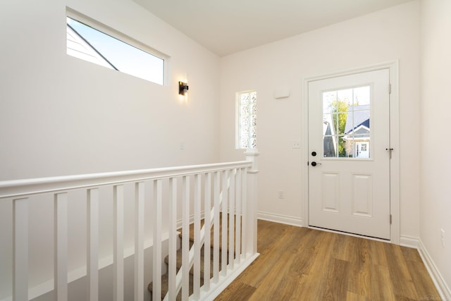 doorway featuring baseboards and wood finished floors