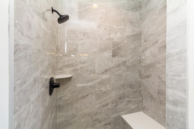 interior details featuring a tile shower