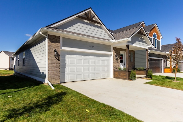 view of front of home with a garage, concrete driveway, brick siding, and a front yard