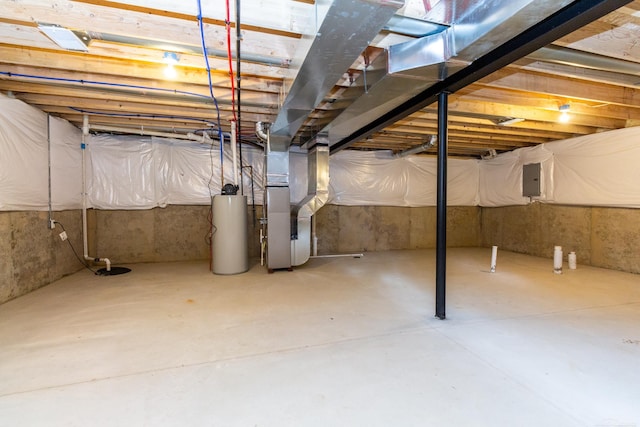 unfinished basement featuring heating unit, electric panel, and gas water heater