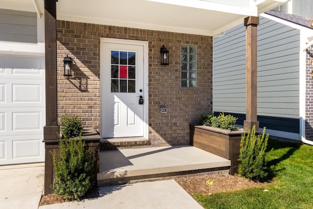 property entrance featuring brick siding and an attached garage