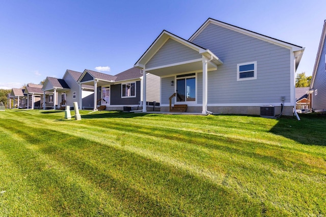 back of house featuring a yard and central AC unit