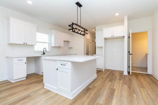 kitchen with light wood-type flooring, recessed lighting, white cabinets, and a center island