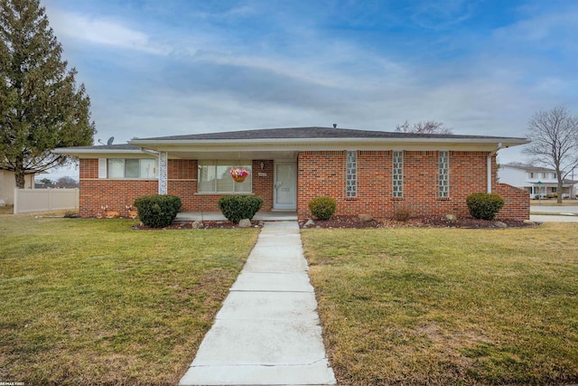 ranch-style house featuring fence, a front lawn, and brick siding