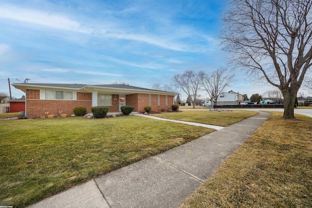 view of front facade with a front yard and brick siding