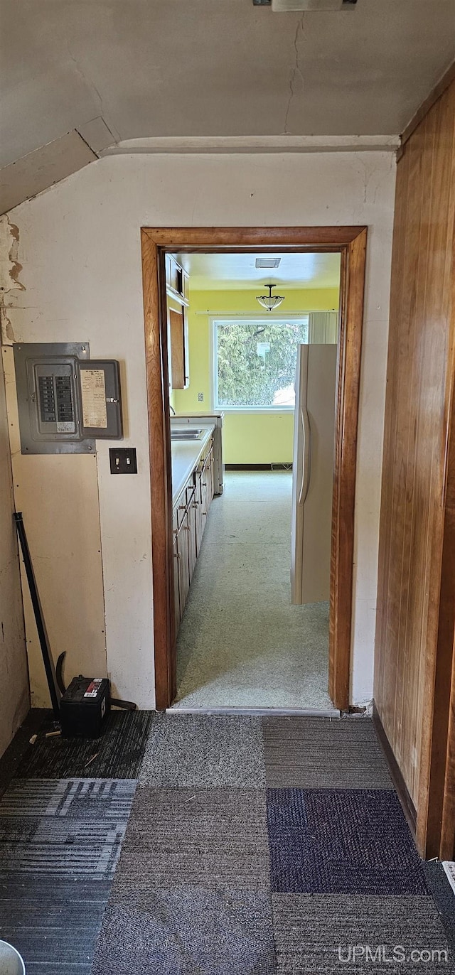 corridor with visible vents, vaulted ceiling, and a sink