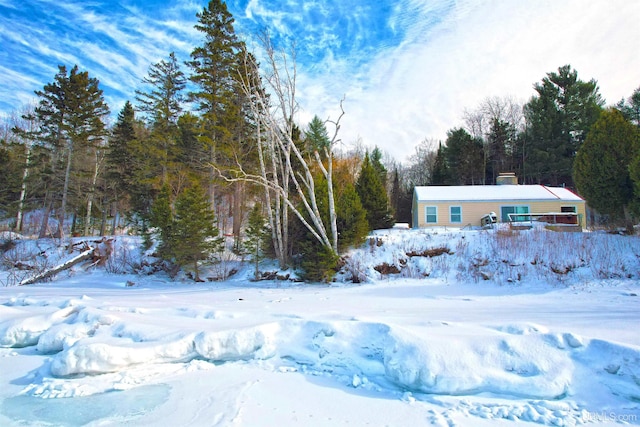 yard layered in snow with a wooded view