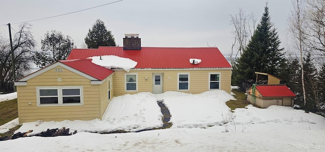 view of front facade featuring metal roof and a chimney