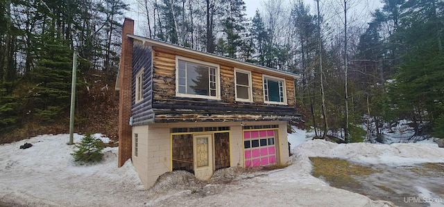 view of front of house featuring a garage and a chimney