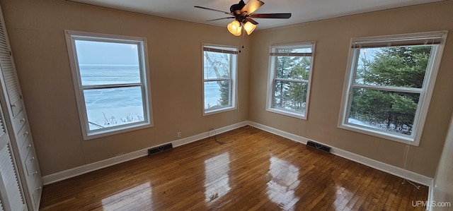 spare room featuring baseboards, visible vents, and hardwood / wood-style floors